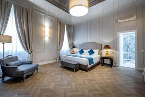 a bedroom with a king sized bed and a chair at Residenza d'epoca Poliziano in Florence