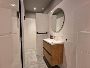 een badkamer met een wastafel en een spiegel bij Appartement Bierkade in Alkmaar