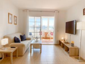 un salon avec un canapé et une table dans l'établissement Fee4Me Casa Emilia few meters from the beach, à Lajita