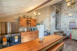 uma cozinha com armários de madeira e uma mesa de madeira em Medieval Manor em Caldicot