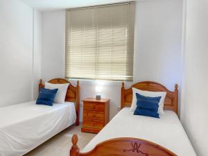 deux lits jumeaux dans une chambre avec fenêtre dans l'établissement Fee4Me Casa Emilia few meters from the beach, à Lajita