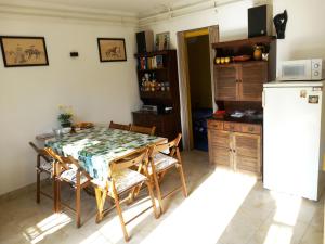 una cucina con tavolo, sedie e frigorifero di Kisfaludy Apartment House a Gárdony