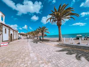 une rue pavée avec des palmiers sur la plage dans l'établissement Fee4Me Casa Emilia few meters from the beach, à Lajita
