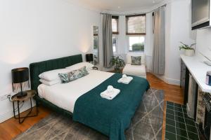 a bedroom with a large bed with a green headboard at Newbridge Road, One bedroom Apartment in Bath
