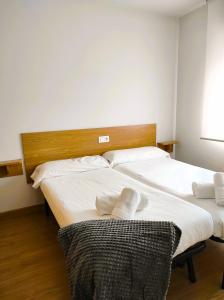 2 Betten in einem Zimmer mit weißer Bettwäsche und Kissen in der Unterkunft HOLIDAY HOMES Figueras AT in Castropol