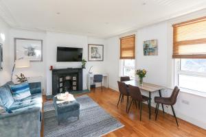 a living room with a table and a fireplace at Newbridge Road, One bedroom Apartment in Bath