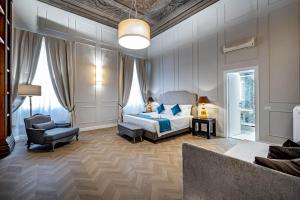 a bedroom with a bed and a chair at Residenza d'epoca Poliziano in Florence