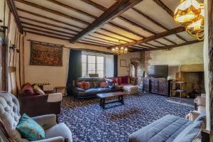 una sala de estar con sofás y TV en una habitación en Medieval Manor en Caldicot