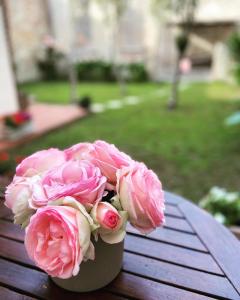 a vase filled with pink roses sitting on a table at Victoria House B&B in Pisa