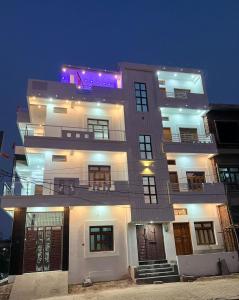een groot wit gebouw met 's nachts verlichting bij Shri Ram International Home Stay Ayodhya in Ayodhya