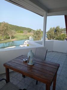 a wooden table on a patio with a view of the water at Acheron rooms in Preveza +57 photos