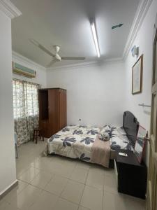 een slaapkamer met een bed en een plafondventilator bij HOMESTAY PANDAN 10 in Melaka