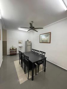 een eetkamer met een zwarte tafel en stoelen bij HOMESTAY PANDAN 10 in Melaka