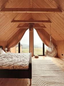 a bedroom with a bed and a hammock at Chaty w chmurach in Komańcza