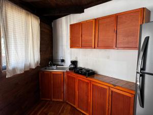 una cucina con mobili in legno e un lavello di LA VILLA DE LA ABUELA a San Cristóbal de Las Casas