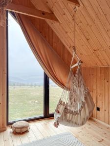 a hammock hanging in a room with a large window at Chaty w chmurach in Komańcza