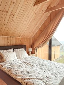 a bedroom with a large bed with a wooden ceiling at Chaty w chmurach in Komańcza
