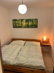 a bed in a bedroom with a painting on the wall at Wohnung mitten im Salzkammergut in Ohlsdorf