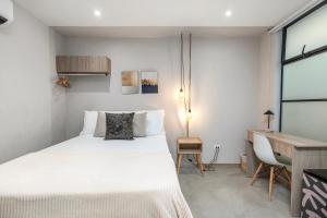 a bedroom with a white bed and a desk at Mohk Boutique by HOUSY HOST in Medellín