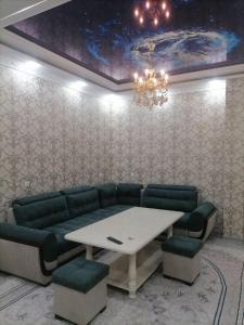 Habitación con sofá, mesa y sillas. en Rudakiy Apartment, en Samarkand