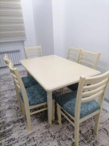 una mesa y sillas blancas con una mesa blanca y 4 sillas en Rudakiy Apartment, en Samarkand