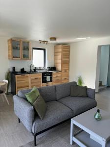 a living room with a couch and a kitchen at Napsugár Vendégház in Zánka