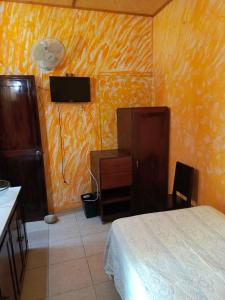 1 dormitorio con 1 cama, escritorio y TV en Posada Familiar Papantla, en Papantla de Olarte