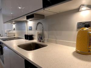 a kitchen with a sink and a yellow bag on the counter at * The Cozy Nest * in London