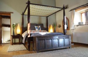 a bedroom with a canopy bed with a wooden frame at Love Cottage in Bell Busk