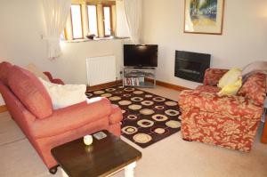 a living room with two chairs and a tv at Love Cottage in Bell Busk