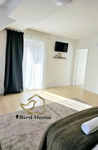 a bedroom with a bed and a flat screen tv at Bird Home Room 15 in Klagenfurt