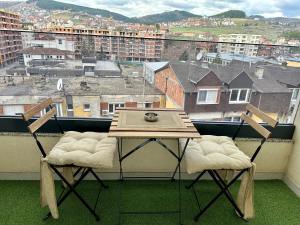 un tavolo e due sedie su un balcone con vista di Apartman Ano LUX a Novi Pazar