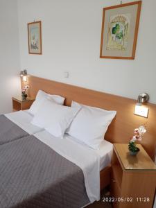 een slaapkamer met een bed met witte lakens en kussens bij Fofi Apartments in Symi