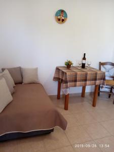 een woonkamer met een bank en een tafel met een fles wijn bij Fofi Apartments in Symi