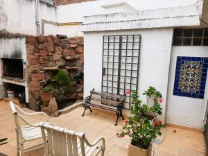 a patio with a bench and a stone wall at General Paz Temp in Cordoba