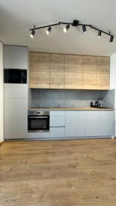 a kitchen with white appliances and wooden cabinets at AR ALBELLI HOUSE II in Košice