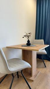 a wooden table with a vase with a plant on it at AR ALBELLI HOUSE II in Košice