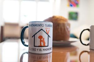 una taza de café con un cartel en una mesa en Apartamento El oso y el Madroño, en Villena