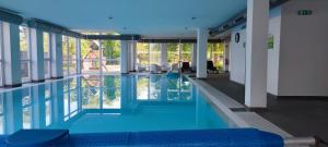 uma piscina com água azul num edifício em FreshGarden Family Resort em Siófok