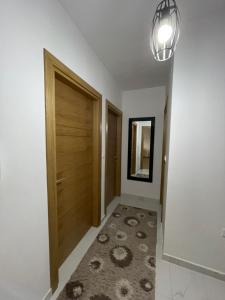 a hallway with a wooden door and a rug at Diamond Apartment in Strumica