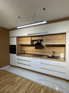 a kitchen with white cabinets and a sink at Diamond Apartment in Strumica