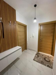 a bathroom with wooden doors and a rug at Diamond Apartment in Strumica