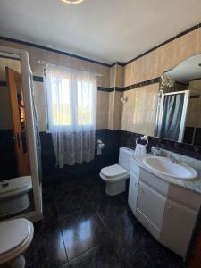 uma casa de banho com um lavatório, um WC e um espelho. em JMCA em Castro-Urdiales