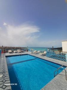 a swimming pool with the ocean in the background at Palm Inn City Hotel in Hurghada