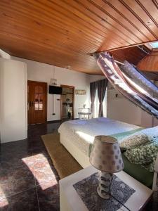 um quarto com uma cama grande e um tecto de madeira em JMCA em Castro-Urdiales