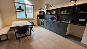 una cucina con tavolo e una sala da pranzo di YFB-170m2 Apartment für bis zu 15, modern, 1min zu UBahn, Ruhige Lage, Parkplätze, WIFI, Netflix, Kindergerecht a Norimberga