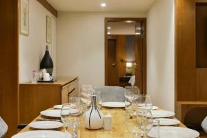 a table with plates and wine glasses on it at Sunday Hotel Vadodara in Vadodara