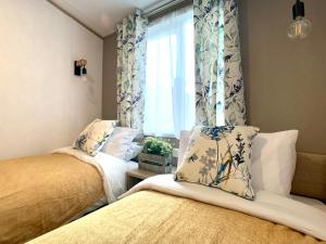 1 dormitorio con 2 camas y una ventana con cortinas en Coniston View 7 en Warton