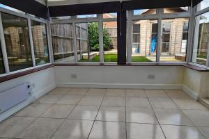 an empty room with large windows in a building at 4 Bedroom Spacious Entire House Sleeps 6 in Great Parndon