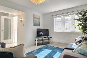 uma sala de estar com um sofá e uma televisão em 4 Bedroom Spacious Entire House Sleeps 6 em Great Parndon